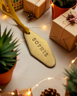 Gold leather label for Christmas Stocking with the name Sophie written in gold.