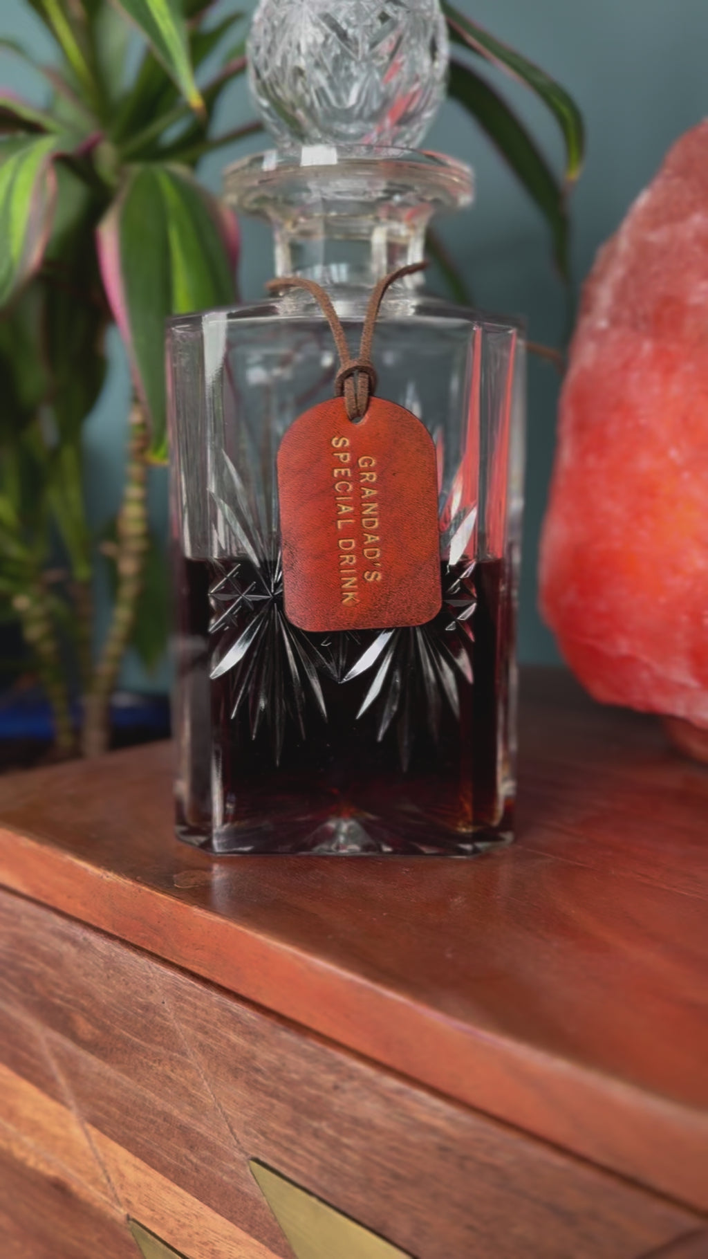 tan leather label attached around the next of a glass decanter.