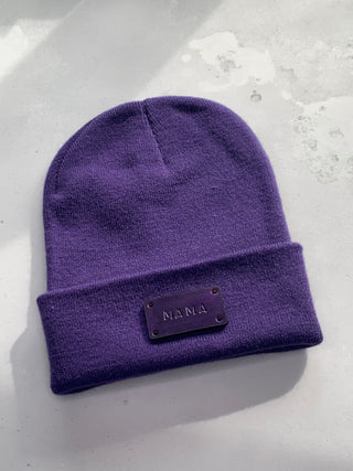 Purple leather MAMA tag on a purple beanie.